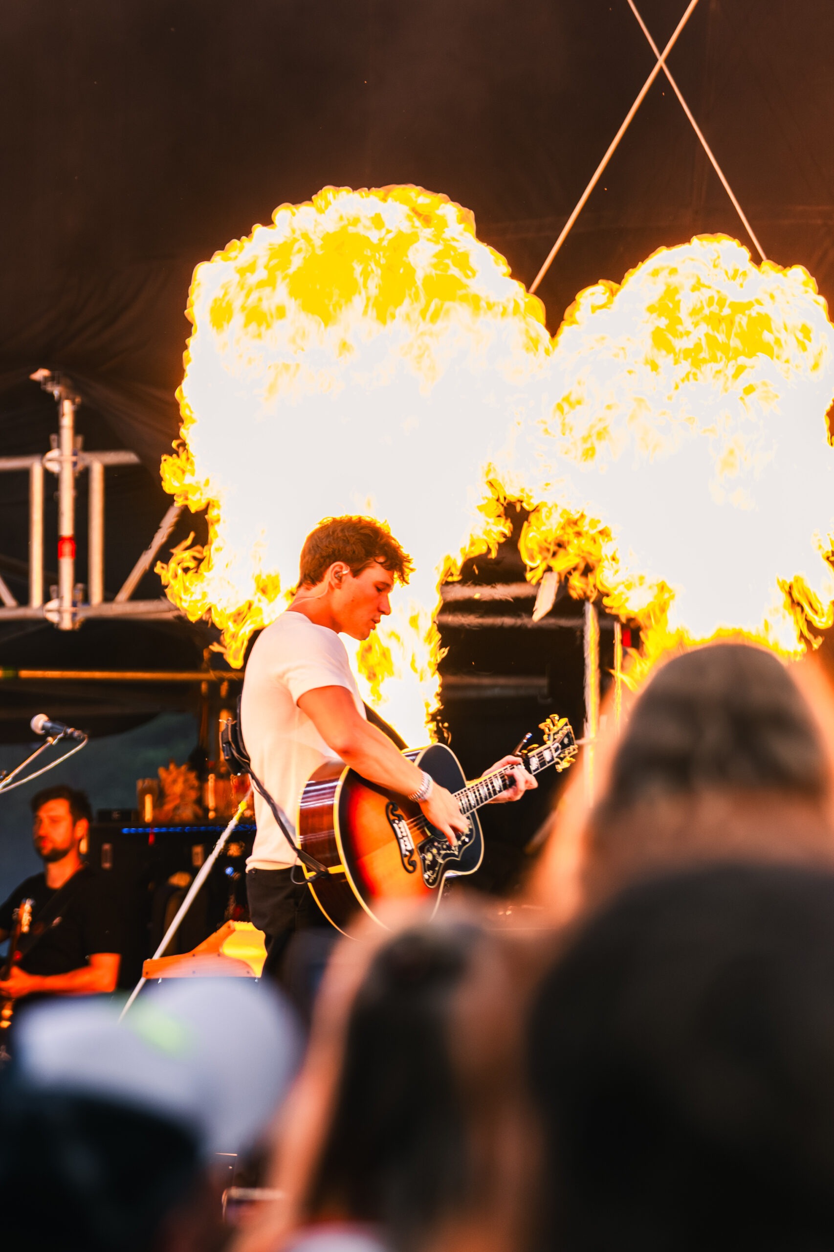 Wincent Weiß spielt auf einer Konzertbühne Gitarre. Im Hintergrund sind Flammenprojektoren aktiv.